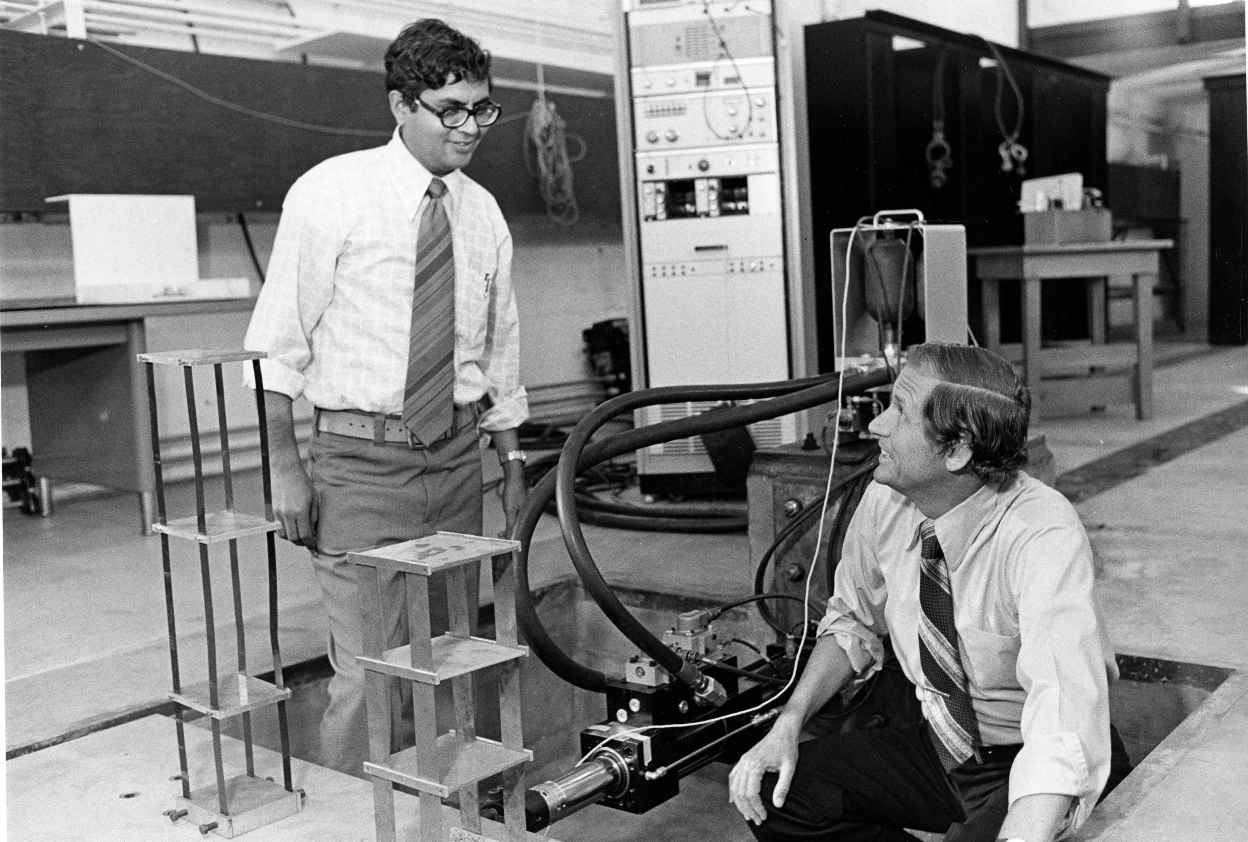 Two men in a laboratory working together on a complex machine.