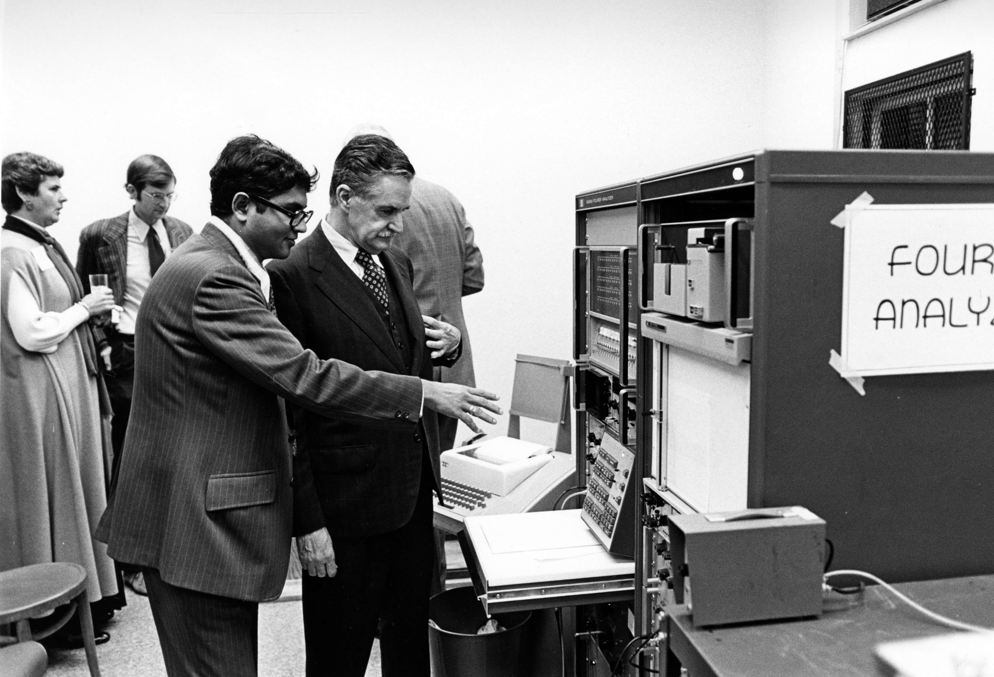 Image of several people, with two men engaged in a discussion.