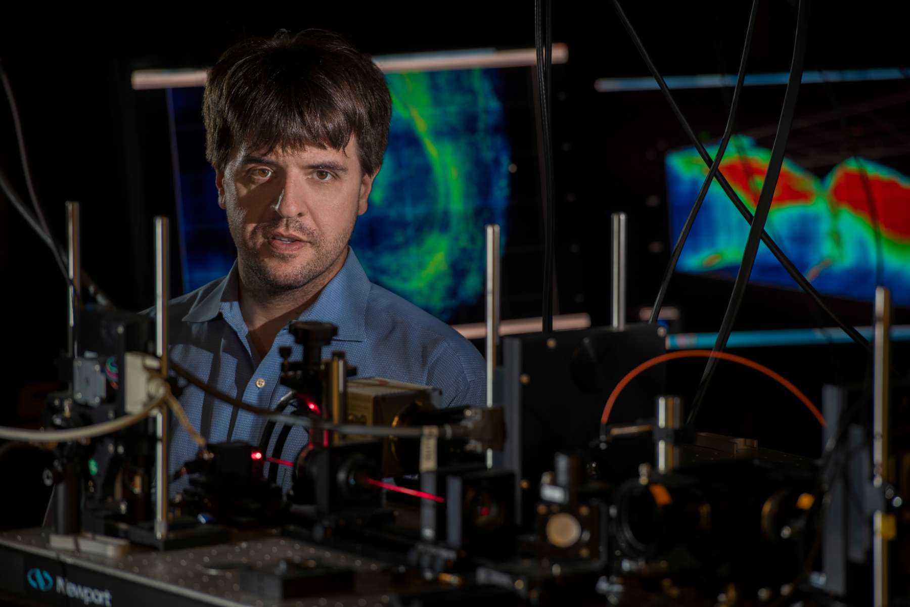 A man dressed in a blue shirt looks at a device, reflecting a moment of focus and attention.